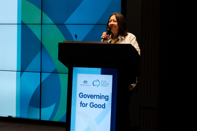Image of Indigenous woman standing behind podium