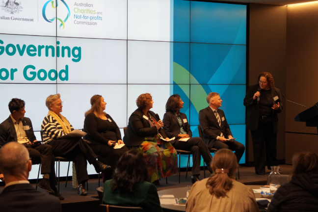 Image of seven people standing on a stage at a conference.