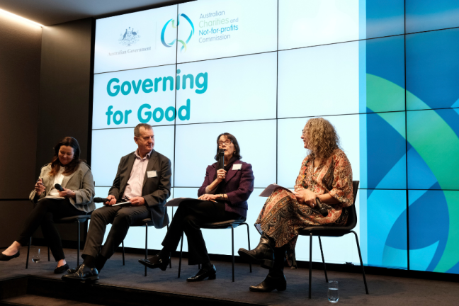 Four people sitting on a stage at a conference